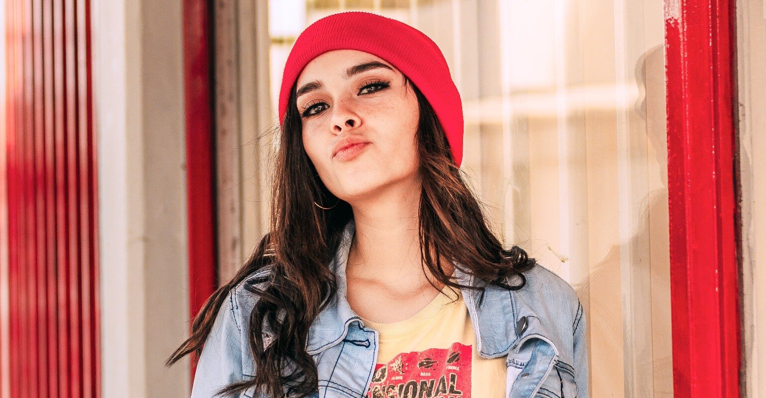Une fille en jean avec un chapeau rouge