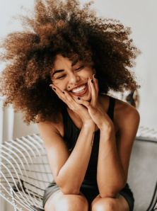 Phụ nữ da đen với kiểu tóc afro cười tít mắt